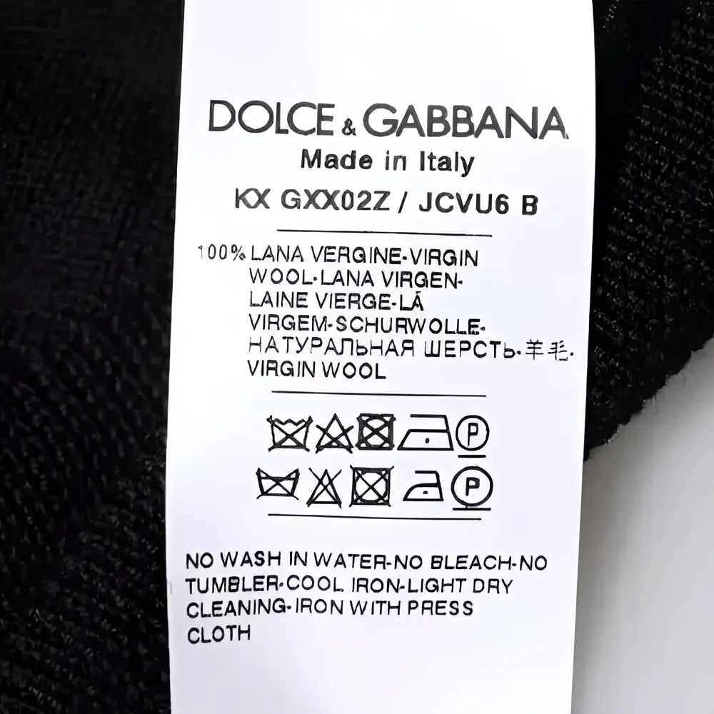 Étiquette dolce & gabbana indiquant pull noir en laine vierge 100 pour cent col rond fabriqué en italie