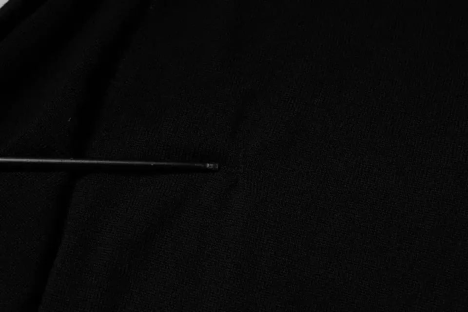Tournevis noir en métal avec manche cylindrique fin et embout arrondi, associé au pull Dolce & Gabbana en laine noire