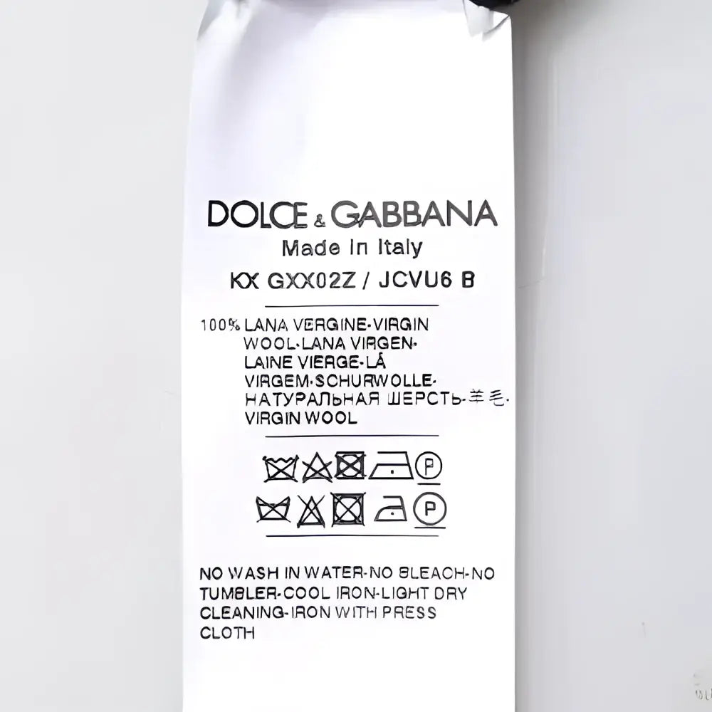 Étiquette dolce & gabbana indiquant pull en laine vierge 100 pour cent noir col rond fabriqué en italie