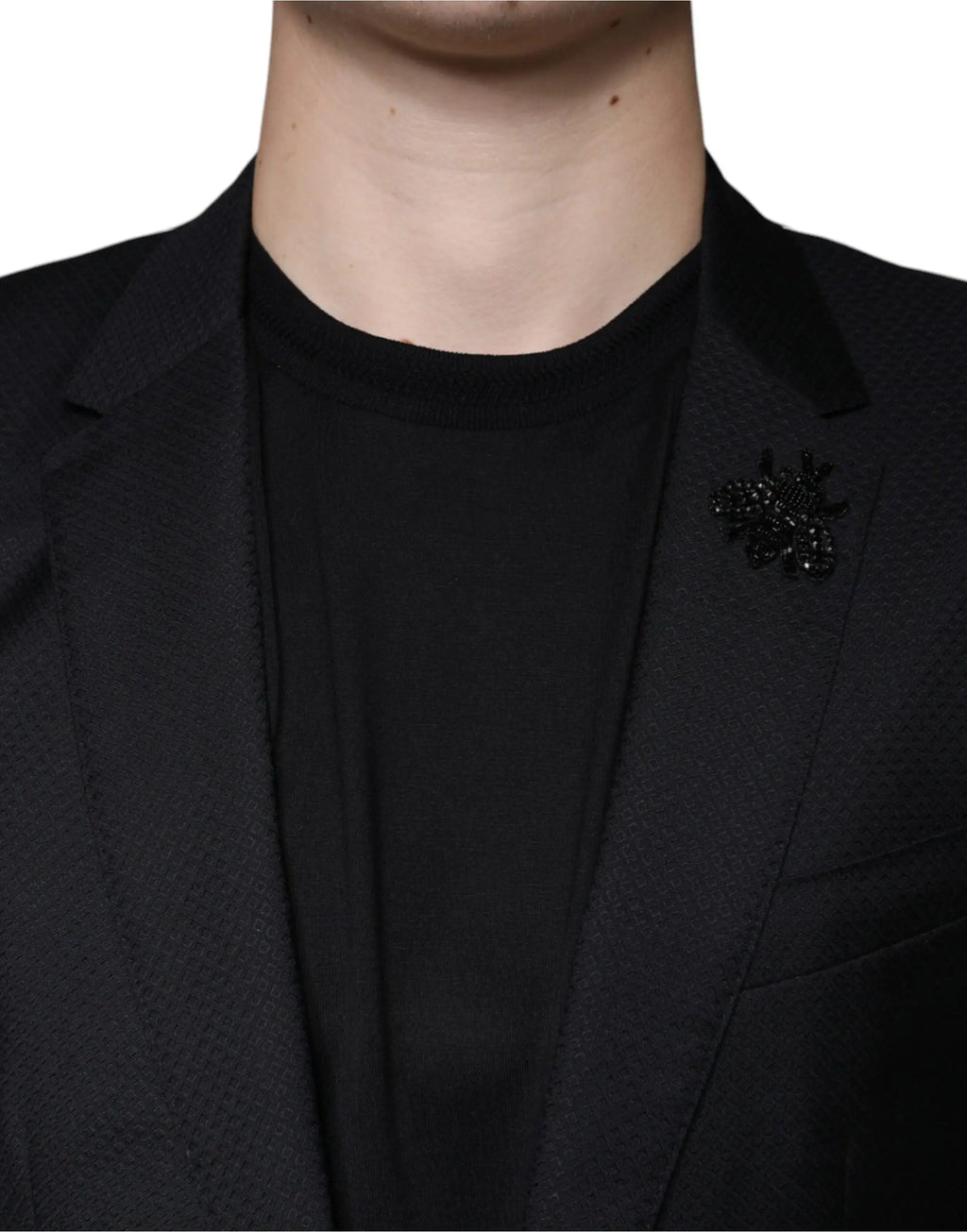 Broche abeille en perles noires épinglée sur le revers dun blazer noir martini dolce gabbana à simple boutonnage