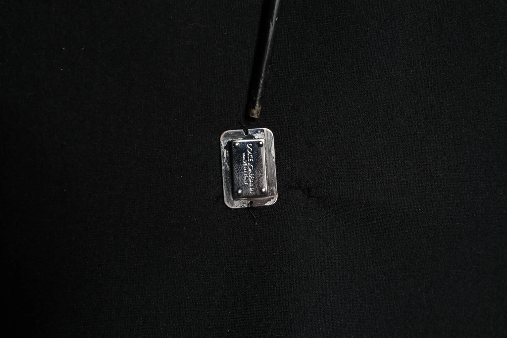 Plaque rectangulaire en métal argenté avec texture et vis sur pull noir en modal dolce & gabbana avec logo dg