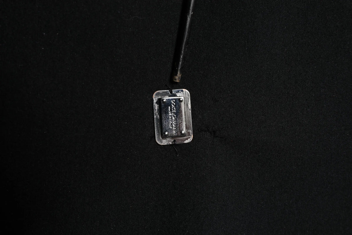 Plaque rectangulaire en métal argenté avec texture et vis sur pull noir en modal dolce & gabbana avec logo dg