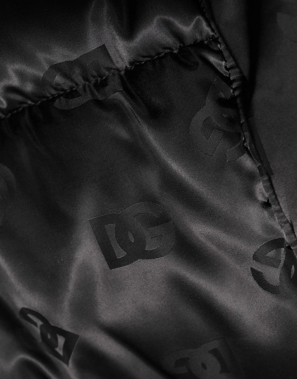Intérieur de veste noire dolce gabbana en nylon matelassé avec doublure satinée et motif monogramme dc subtil