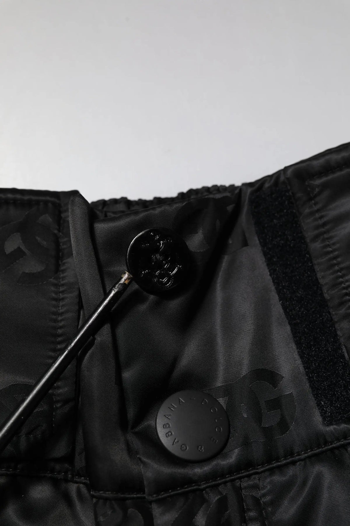 Fermeture à bouton chanel noir sur veste en nylon noir avec motif monogramme subtil dolce gabbana pantalon noir dg logo
