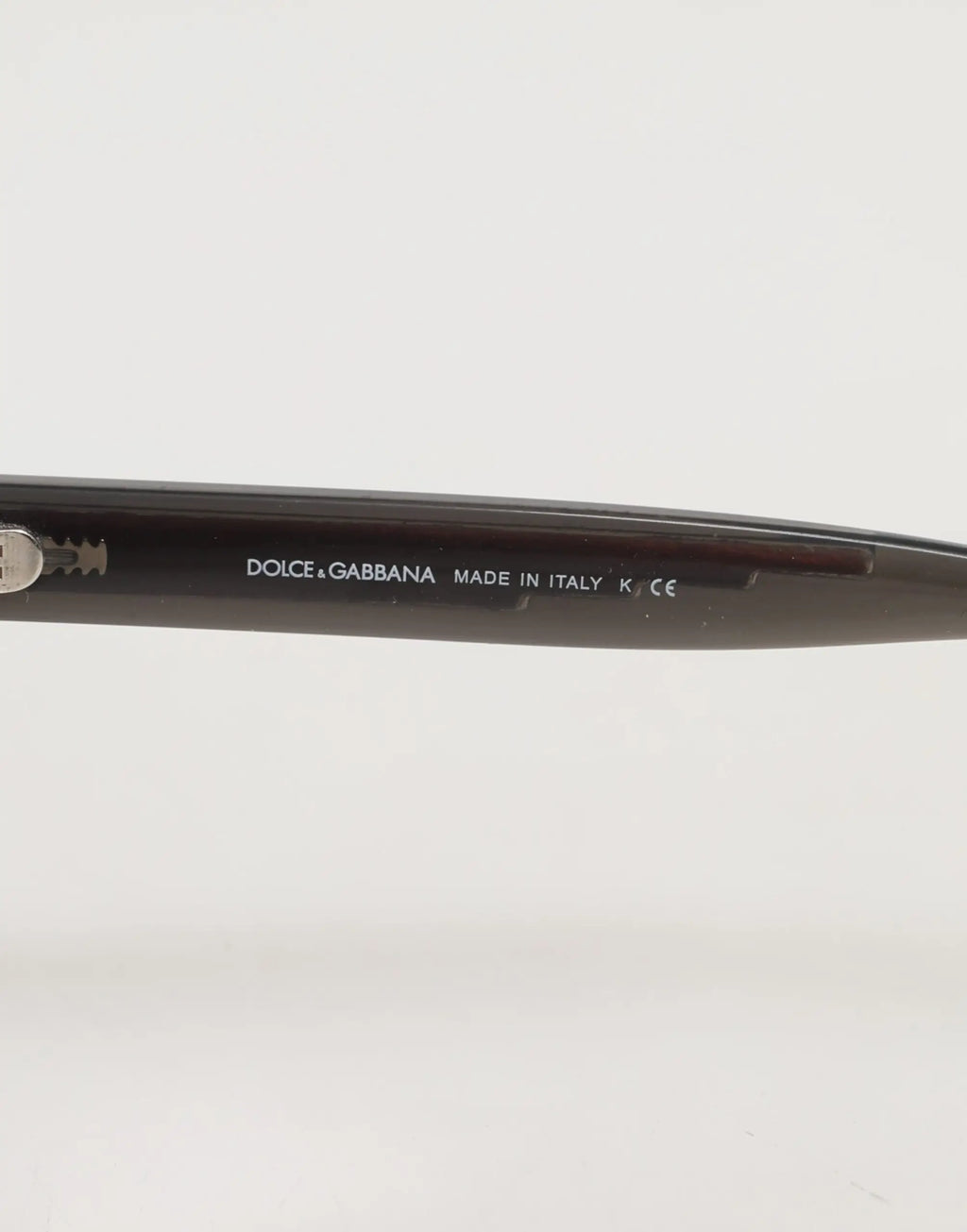 Lunettes de soleil dolce & gabbana noires style cat eye avec cadre noir poli et détails gravés de la marque