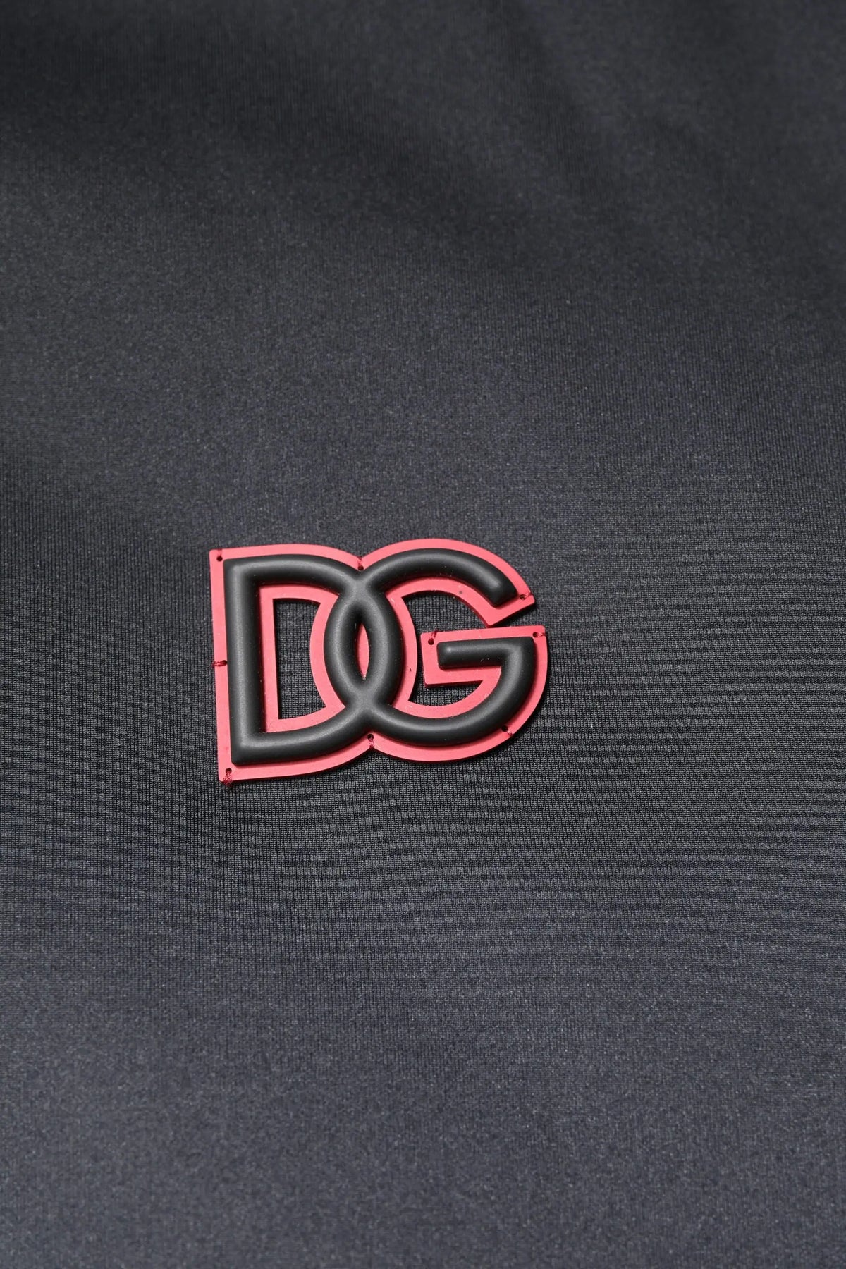 Patch logo dg noir et rose sur tissu foncé de la veste dolce gabbana noire en polyester à zip intégral et capuche
