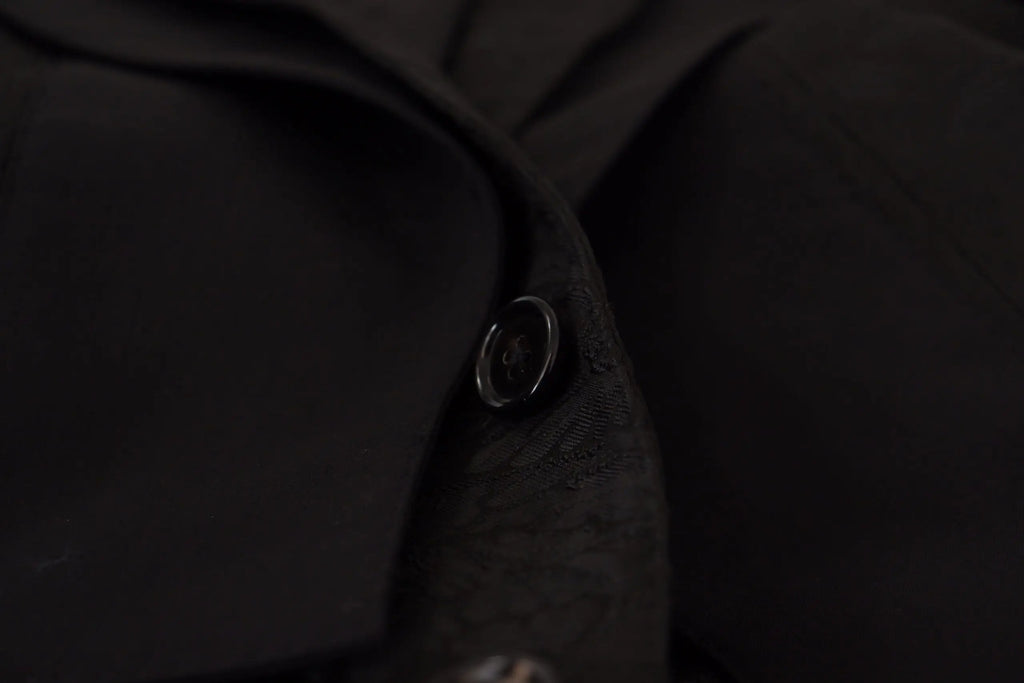 Un bouton noir élégant à finition métallique subtile sur un tissu foncé du costume formel martini 2 pièces en polyester de dolce & gabbana