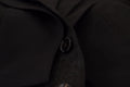 Un bouton noir élégant à finition métallique subtile sur un tissu foncé du costume formel martini 2 pièces en polyester de dolce & gabbana