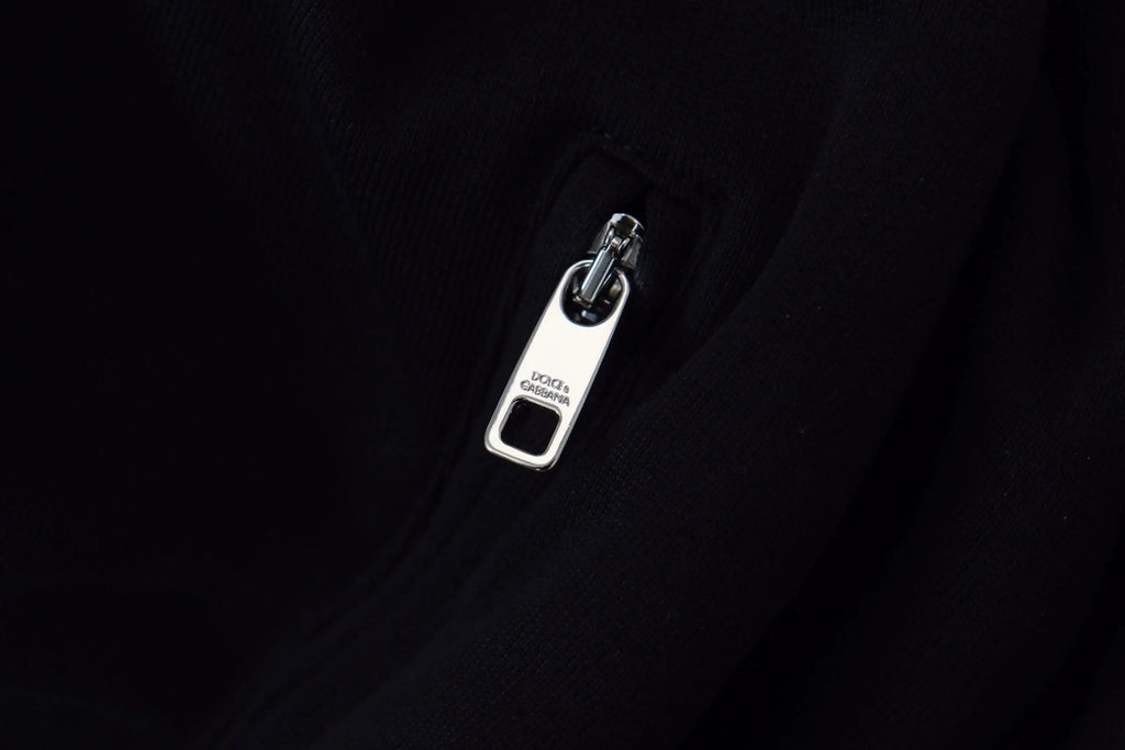 Fermeture éclair en métal argenté gravée dolce & gabbana sur tissu noir de la veste à capuche zippée en polyester noir