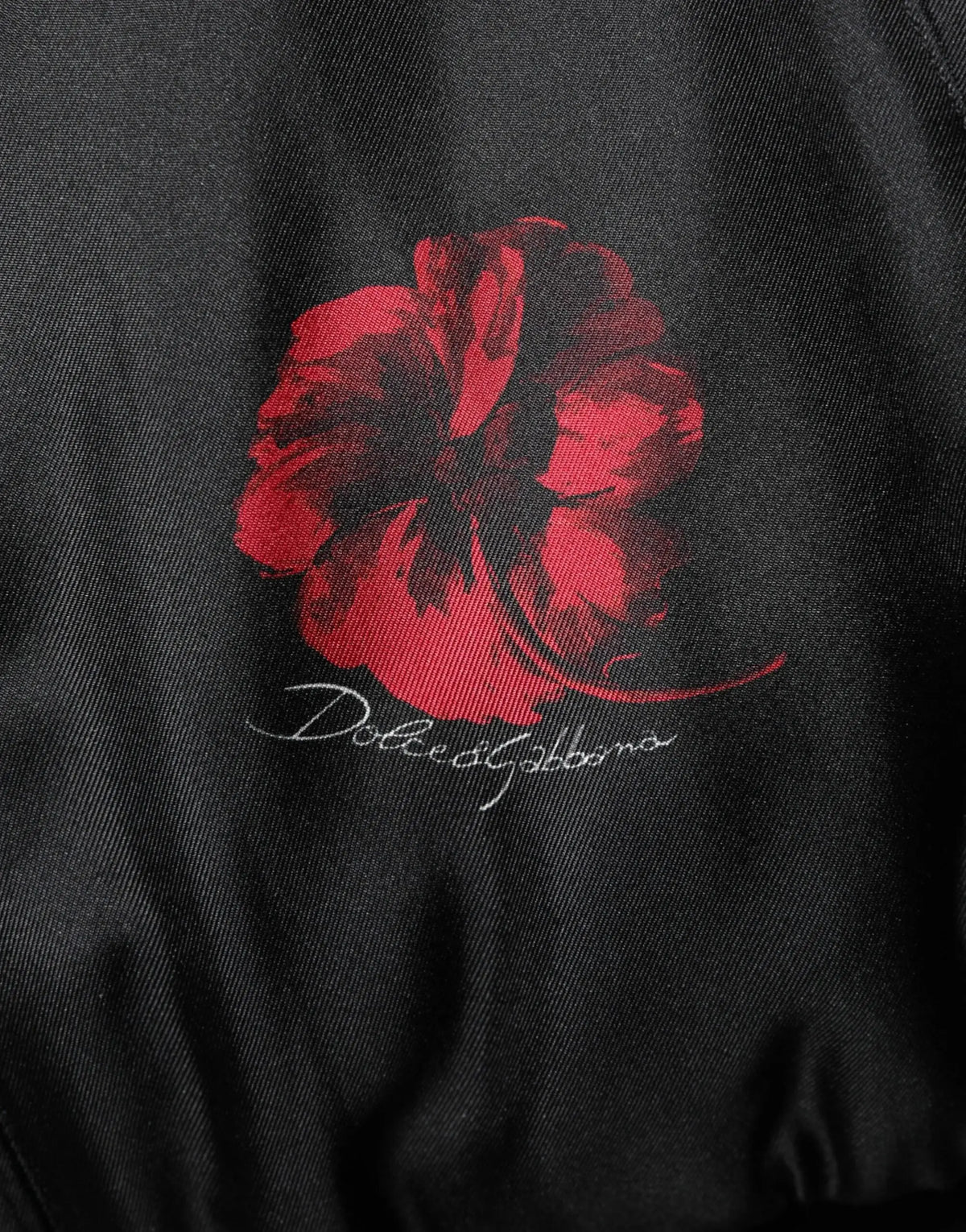 Veste bomber en soie noire dolce gabbana avec motif floral coquelicot rouge et signature blanche au dos