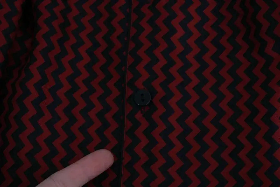 Bouton noir sur chemise décontractée dolce & gabbana à motif zigzag rouge et noir