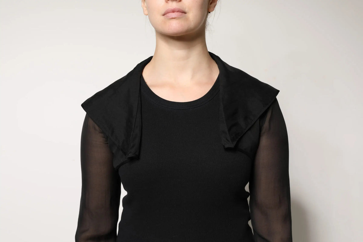 Blouse noire en soie dolce & gabbana avec manches longues transparentes et détail volanté aux épaules