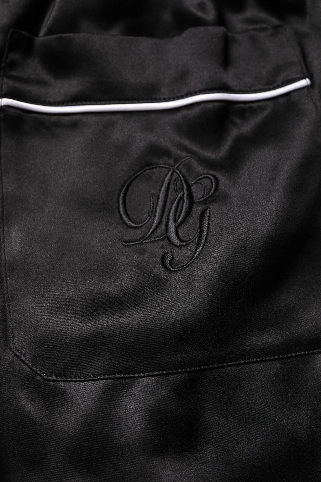 Pantalon de pyjama noir en satin dolce gabbana avec bordure blanche et monogramme brodé pour une tenue de nuit élégante