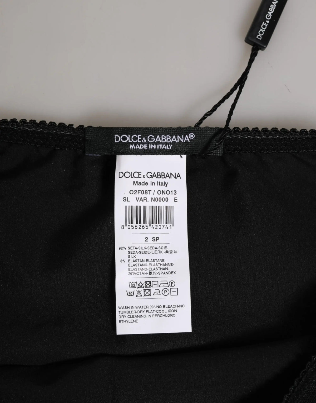 Étiquette noire dolce & gabbana en soie avec étiquette blanche indiquant 92 pour cent soie pour culotte noire extensible taille haute