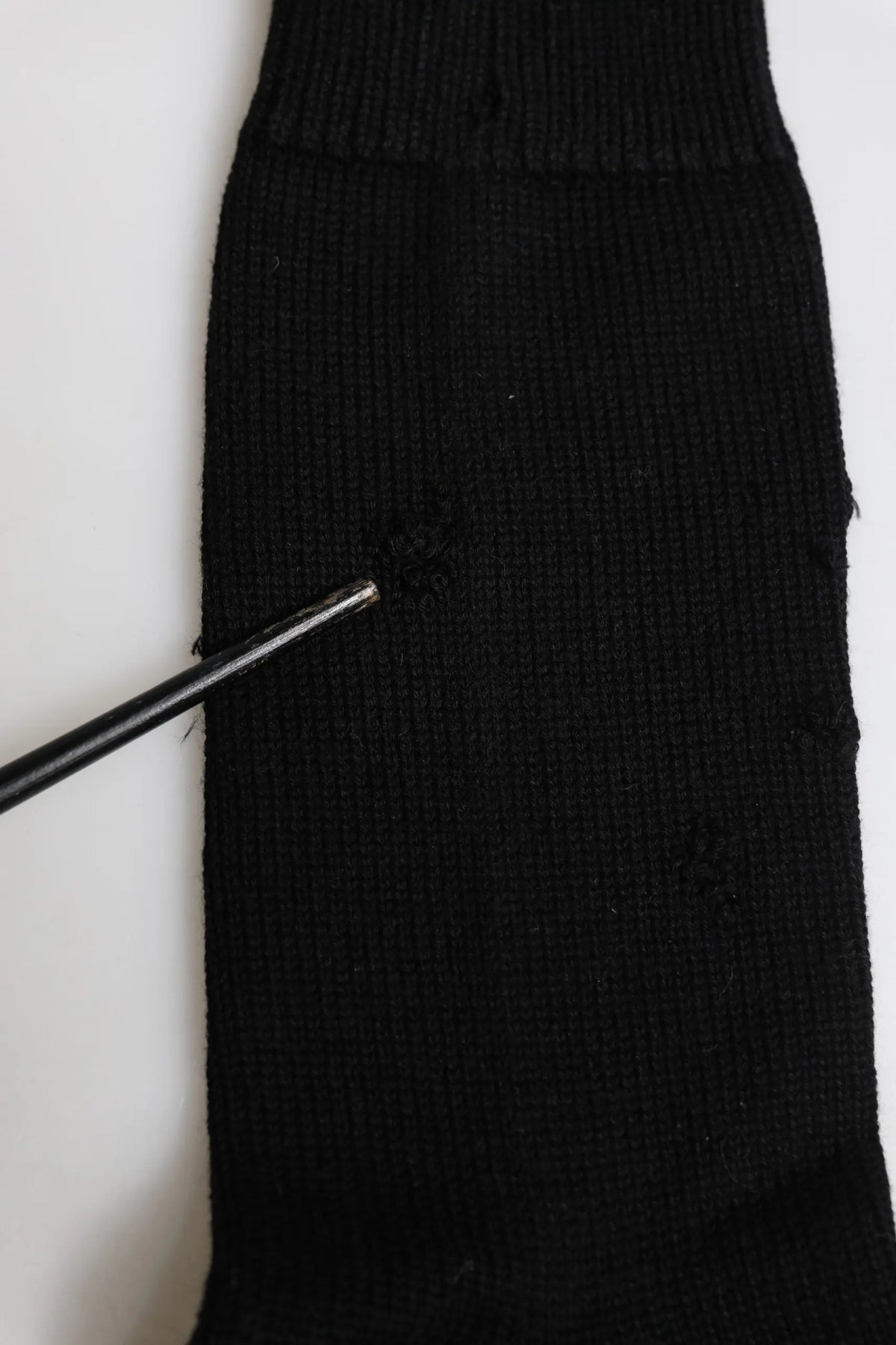 Dolce & gabbana chaussette homme mi mollet noire en maille côtelée stretch avec une petite déchirure près du haut