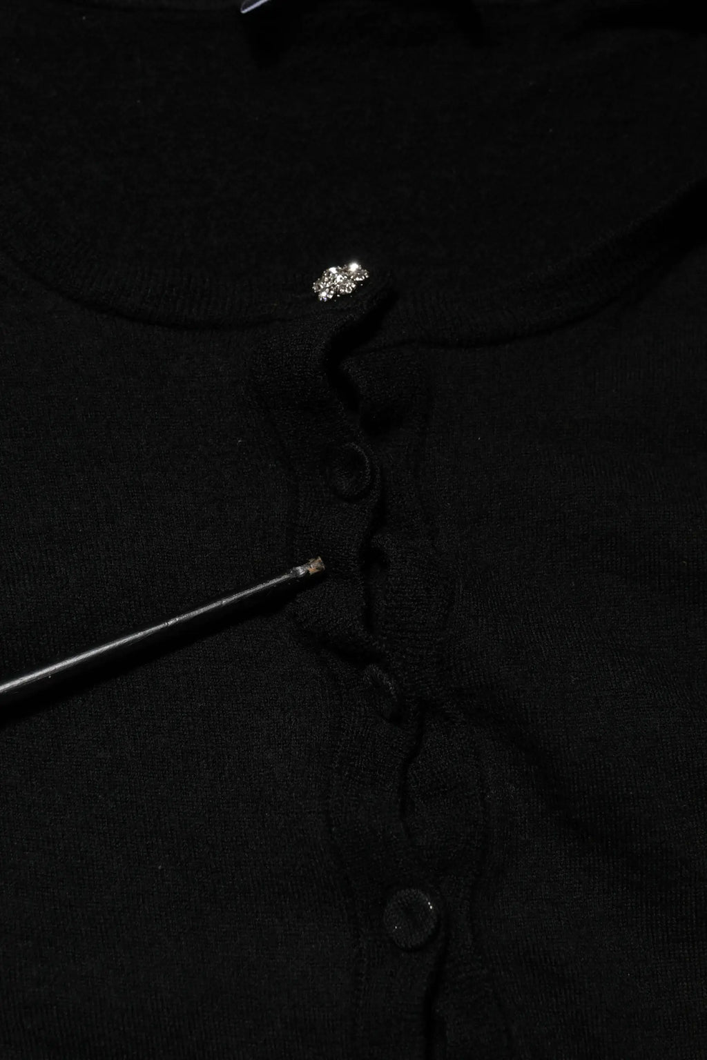 Cardigan noir en maille dolce gabbana avec bouton argenté décoratif en haut et boutons sombres assortis devant