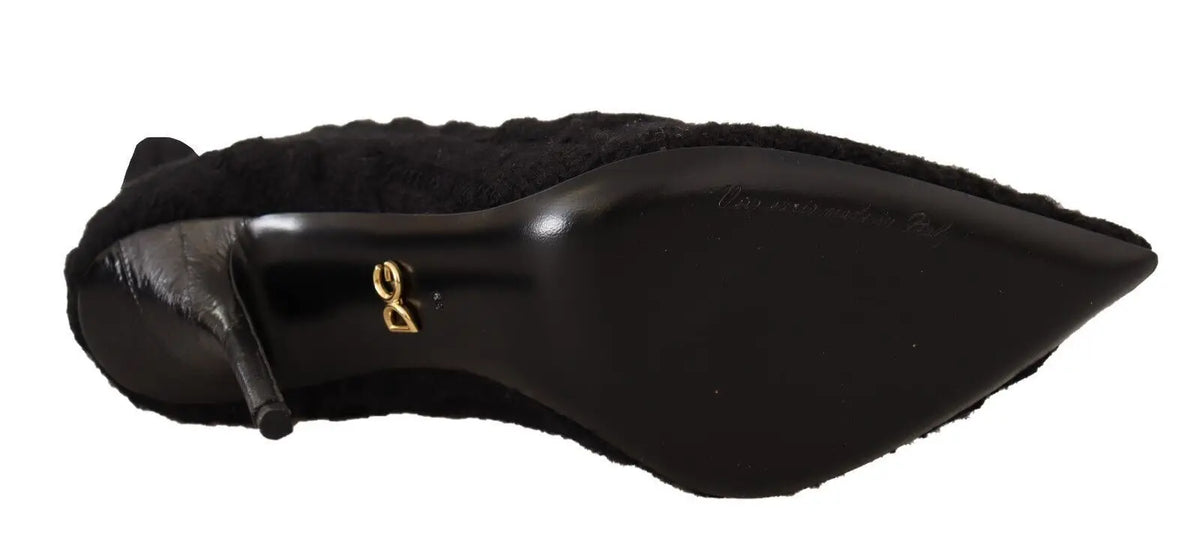 Vue arrière de bottines dolce & gabbana noires en daim stretch avec talon haut et logo doré sur le talon