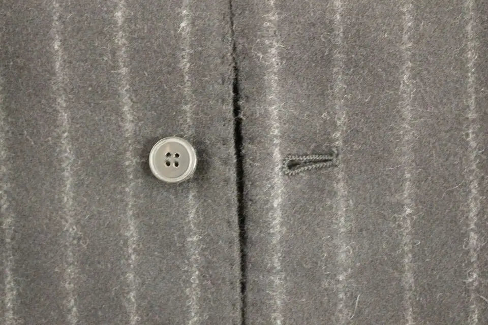 Gilet dolce & gabbana en laine noire rayée avec veste en laine gris à fines rayures et bouton argenté à quatre trous