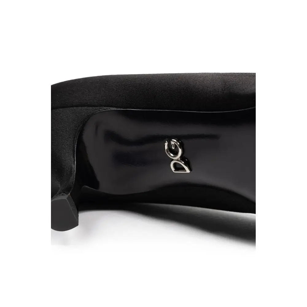 Vue arrière de pompe dolce gabbana noire en cuir verni avec dessus en daim et logo argenté dg au talon