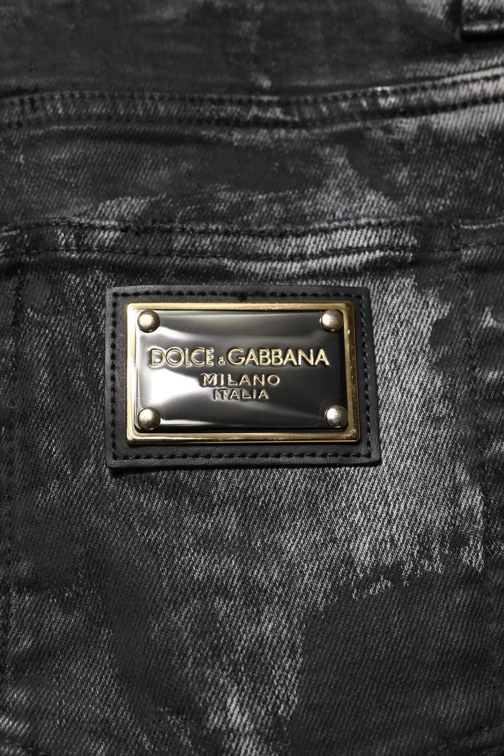 Jean skinny en denim noir délavé dolce gabbana avec étiquette métallique dorée milano italia visible au dos
