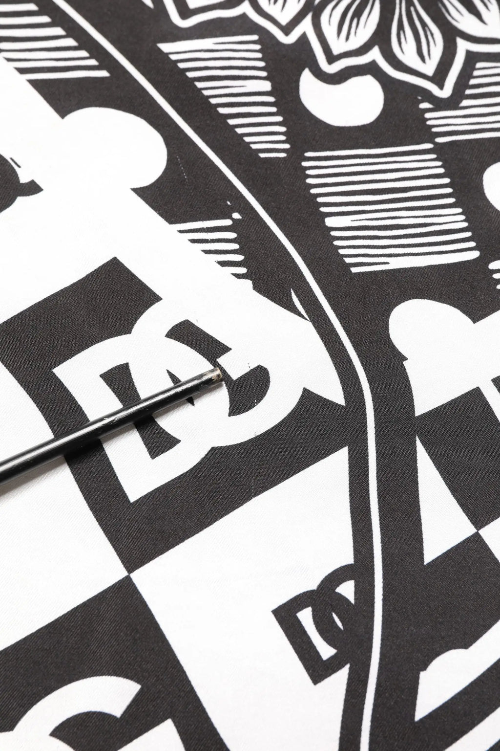 Tee graphique noir et blanc dolce et gabbana avec logo dc stylisé sur fond à carreaux