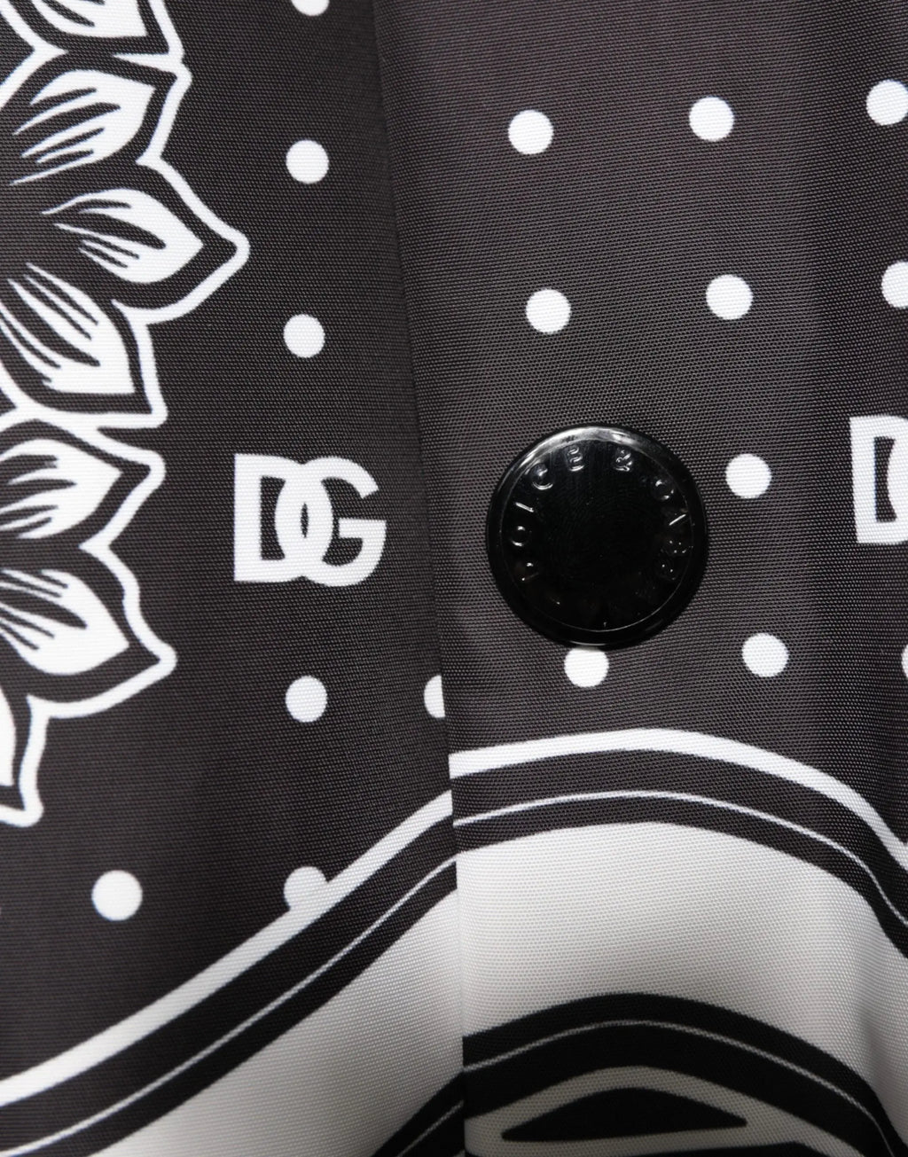Bouton noir dolce gabbana gravé blanc sur tissu noir blanc à motifs floraux et pois sur blouson bomber homme