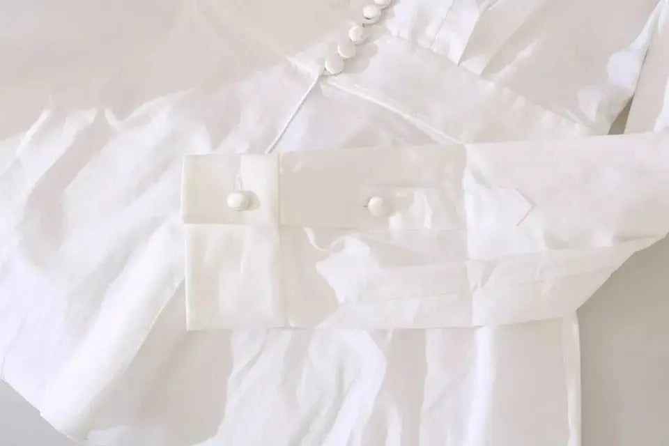Blouse dolce & gabbana blanche avec col classique et plis subtils sur le devant boutons décoratifs noirs et blancs
