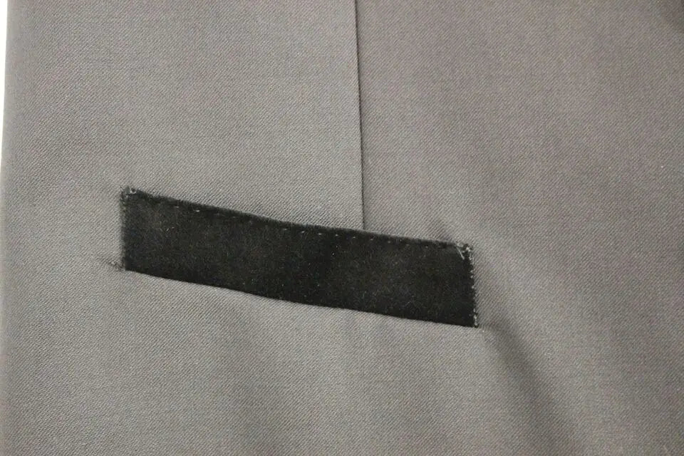 Patch en tissu gris avec couture foncée sur un gilet formel noir en laine dolce & gabbana