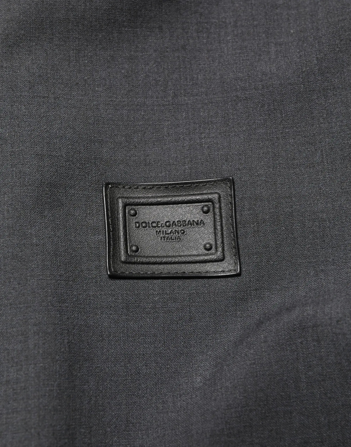 Patch en cuir noir dolce gabbana milano italia embossé en argent sur veste bomber homme noire en laine à zip intégral