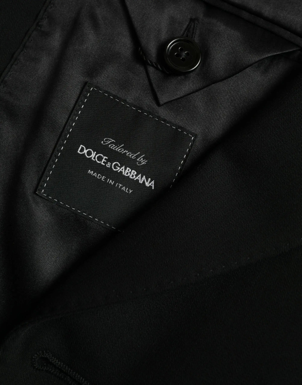 Étiquette noire dolce & gabbana avec couture blanche sur manteau blazer en laine noir à simple boutonnage