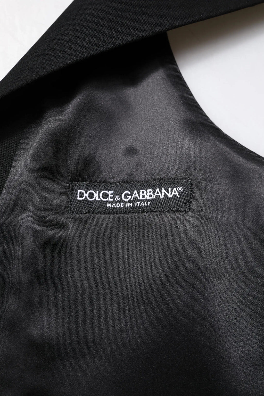 Étiquette noire en satin avec broderie blanche dolce & gabbana made in italy pour veste sans manches en laine noire formelle