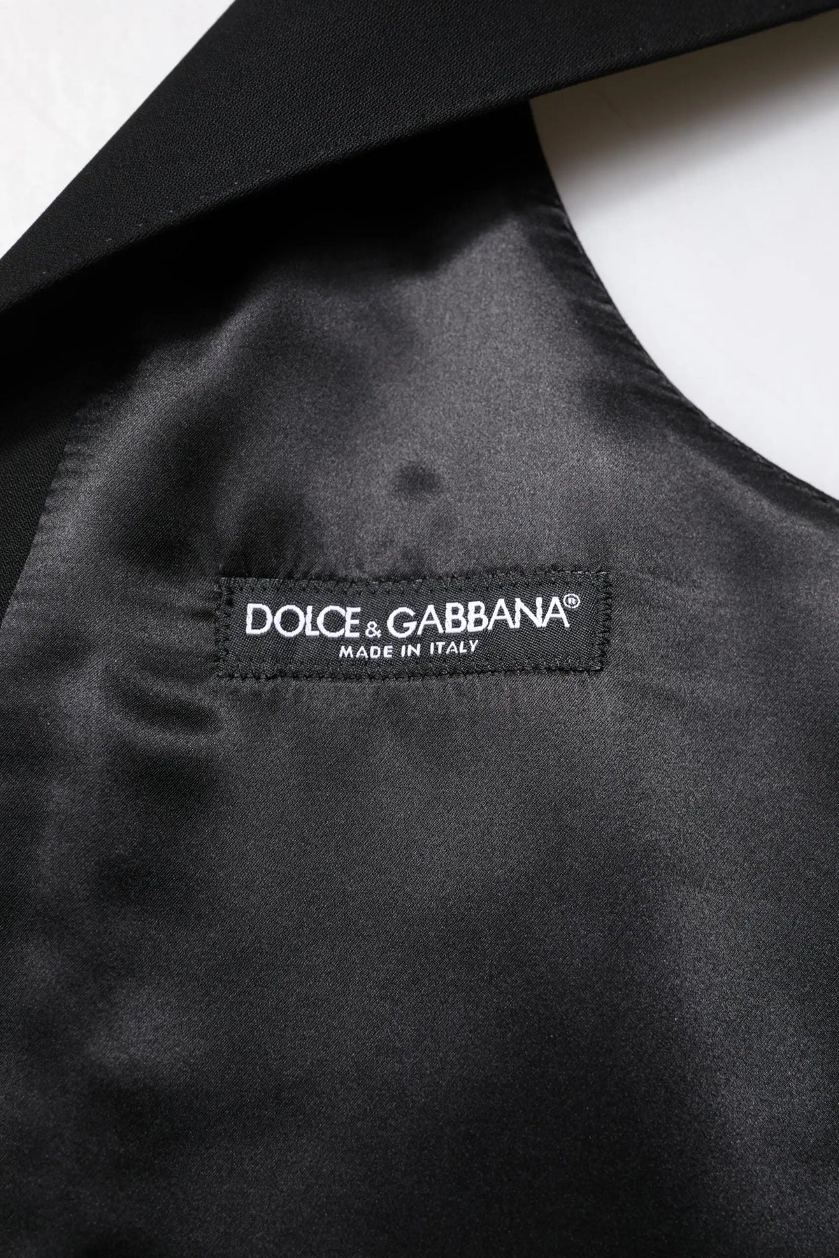 Étiquette noire en satin avec broderie blanche dolce & gabbana made in italy pour veste sans manches en laine noire formelle