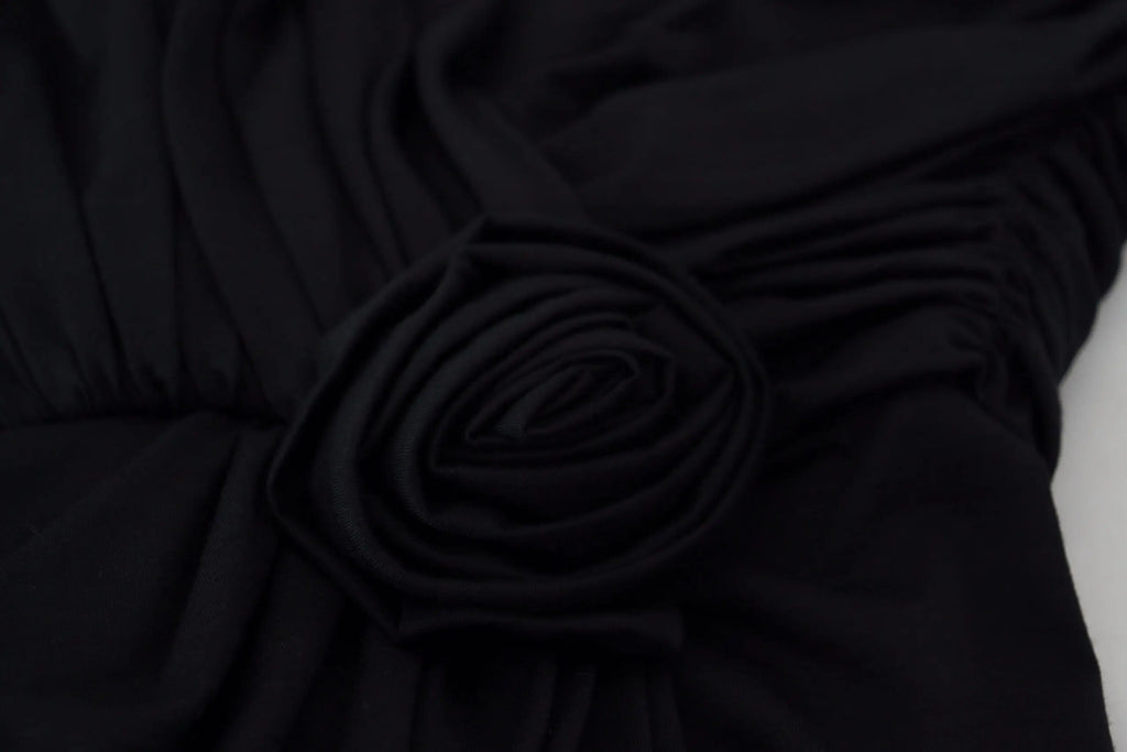 Détail de rose en tissu noir sur robe fourreau en laine à épaule unique dolce & gabbana