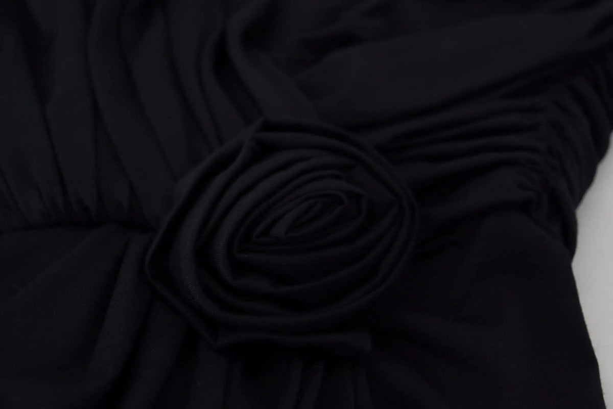 Détail de rose en tissu noir sur robe fourreau en laine à épaule unique dolce & gabbana