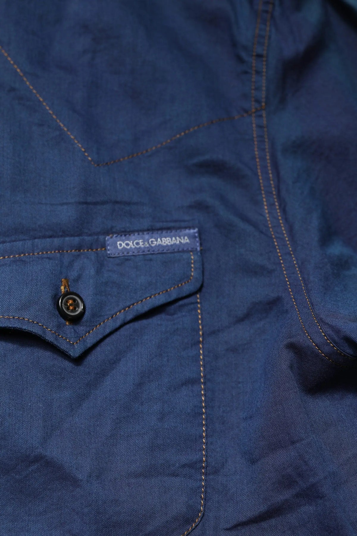 Veste en jean bleu profond avec texture subtile, surpiqûres tan contrastantes et patch marque dolce & gabbana