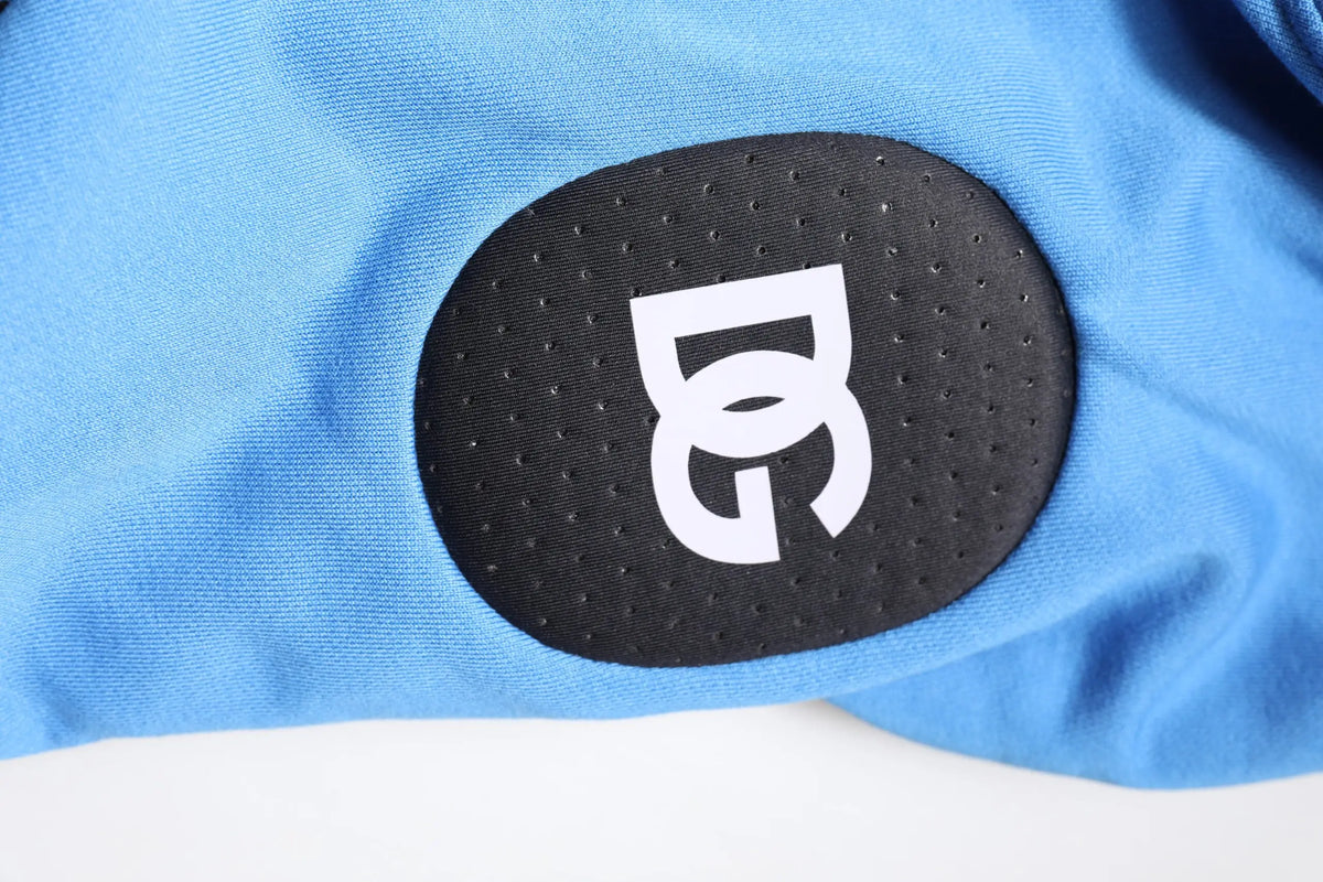 Patch circulaire noir perforé avec logo blanc stylisé sur tissu bleu clair de sweat sans manches homme dolce gabbana coton