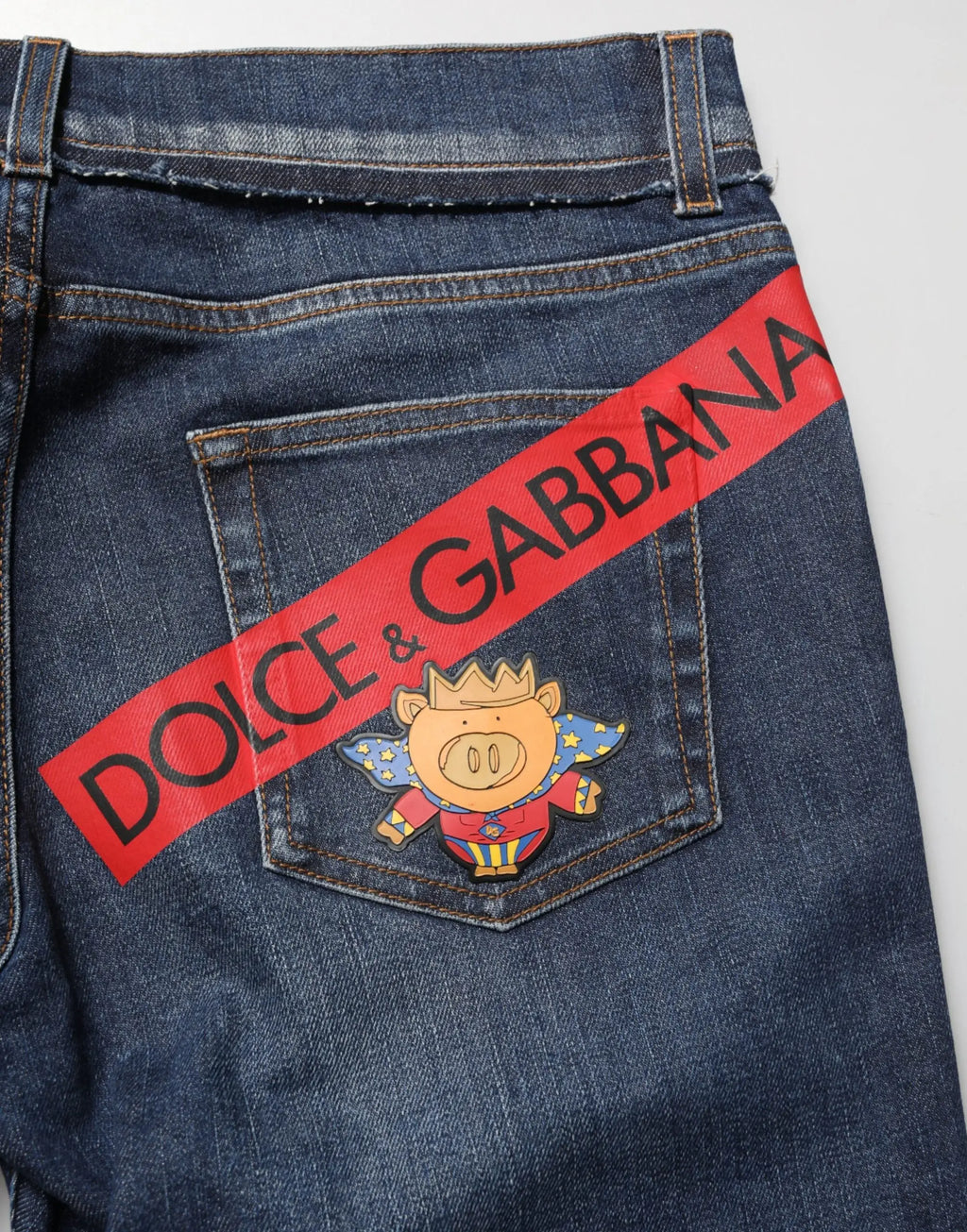 Jeans skinny en coton extensible bleu dolce gabbana avec bande diagonale rouge et patch cochon coloré au dos