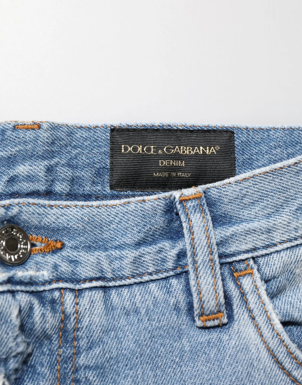Jean en denim bleu clair déchiré avec étiquette noire dolce & gabbana cousue à la taille
