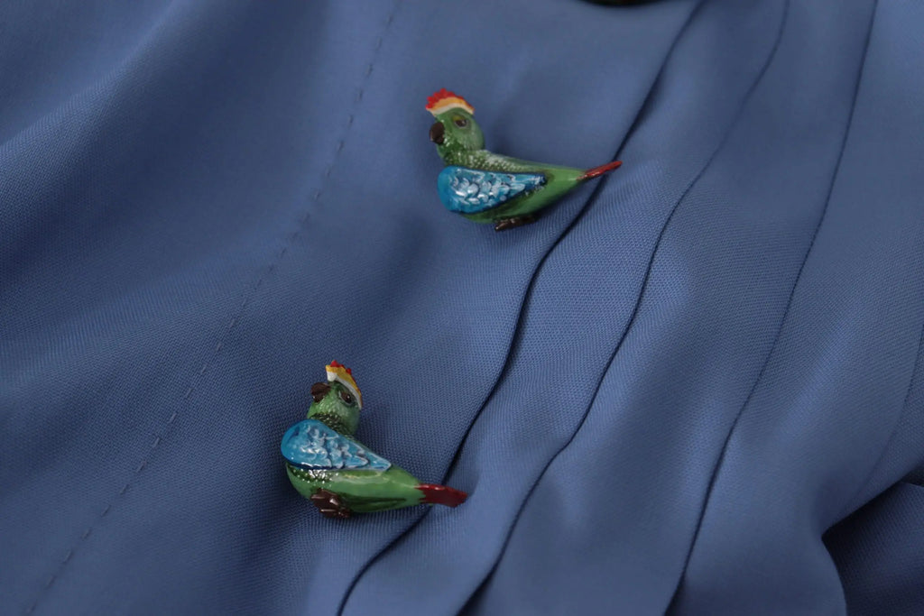 Deux broches petites perroquet colorées sur tissu bleu foncé du mini jupe plissée en laine bleu embellie Dolce & Gabbana