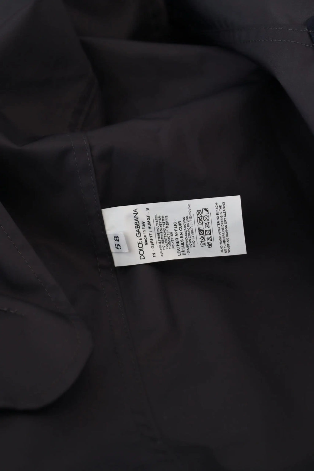 Label d entretien noir dolce gabbana avec texte blanc pour manteau bleu à capuche double boutonnage homme