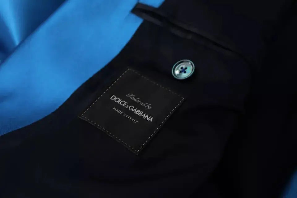 Patch en cuir noir avec texte blanc brodé tailored by dolce & gabbana sur costume formel bleu en soie jacquard