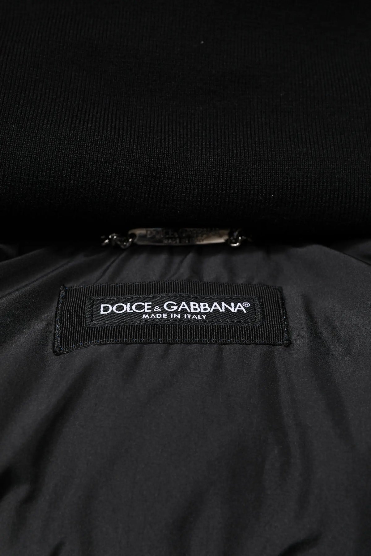 Étiquette noire dolce & gabbana brodée blanche faite en italie sur tissu intérieur texturé de la veste matelassée à capuche bleu logo pleine fermeture éclair