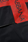 Une poignée de parapluie en métal noir poli à côté du tissu rouge et noir dolce & gabbana du bomber à capuche zippé intégral bleu logo