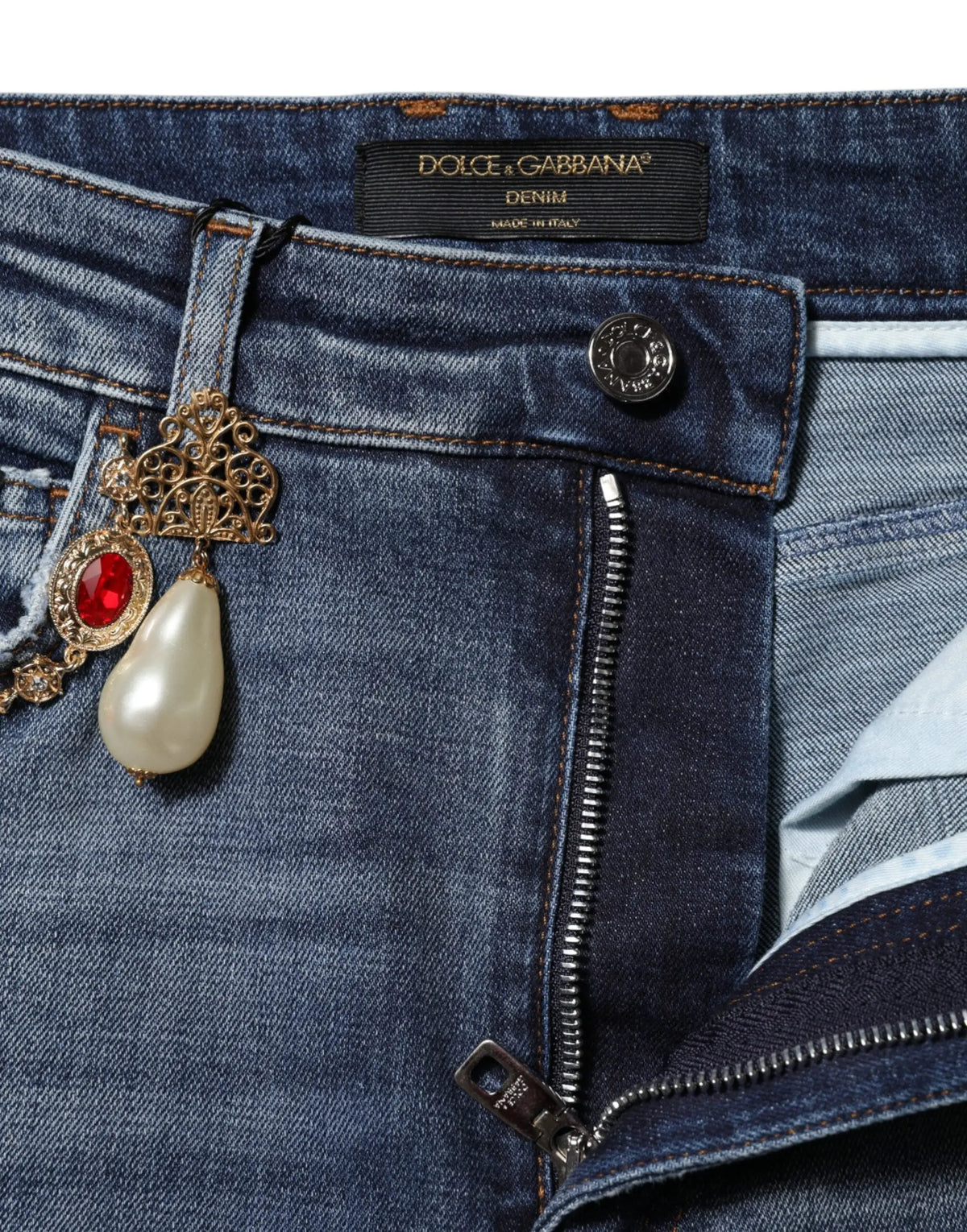 Jean en denim bleu dolce & gabbana avec broche décorative en or orné de pierre rouge et perle pendante