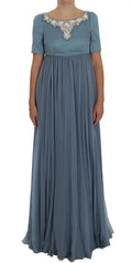 Une robe longue bleu poussière de dolce & gabbana en soie avec jupe plissée et col orné de cristaux et perles