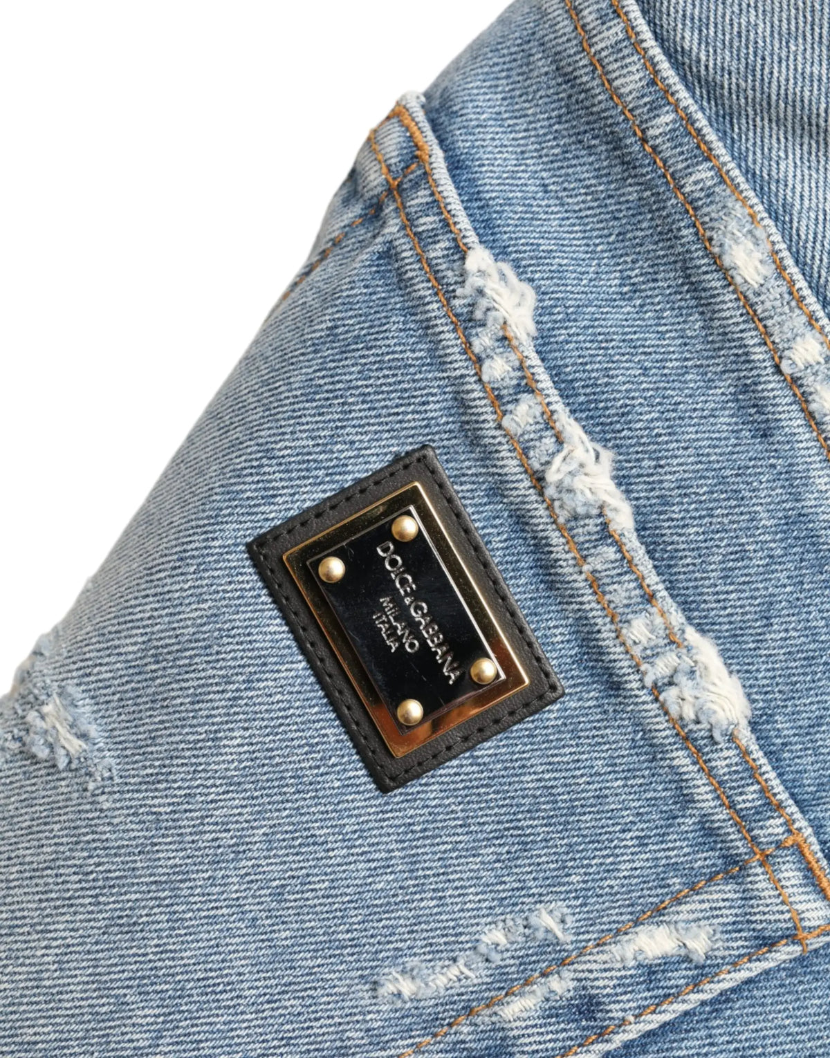 Patch en cuir noir avec clous dorés et plaque métallique dolce gabbana milano sur short bermuda bleu déchiré