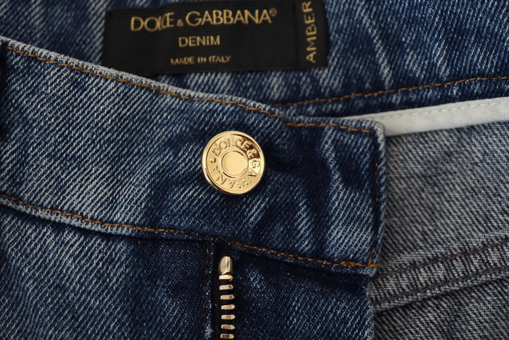 Bouton circulaire doré gravé dolce & gabbana sur jean bleu délavé en coton skinny tattered de dolce & gabbana