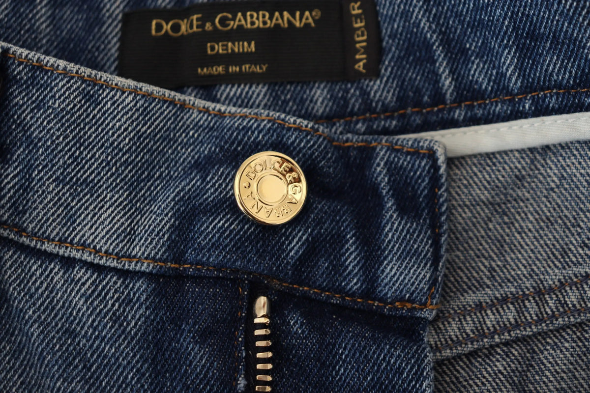 Bouton circulaire doré gravé dolce & gabbana sur jean bleu délavé en coton skinny tattered de dolce & gabbana