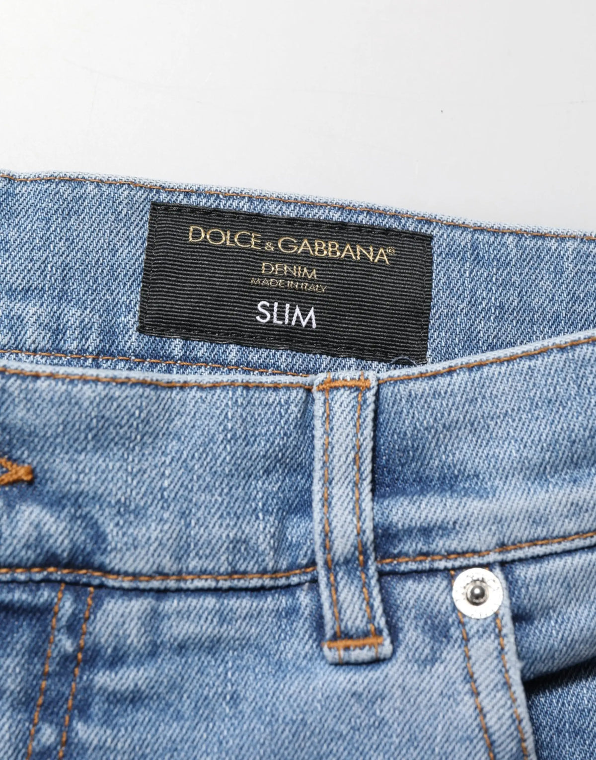 Un jean denim coton bleu clair dolce gabbana slim fit avec une étiquette noire et effet usé
