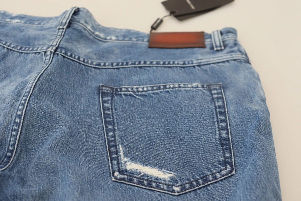 Vue arrière de jeans décontractés bleu lavé en coton dolce & gabbana avec patch usé sur la poche arrière et étiquette cuir marron